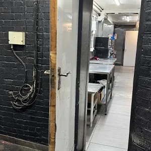 Fire Door Deficiency — Missing intumescent strips and no self‑closing device, compromising compartmentation to the kitchen area