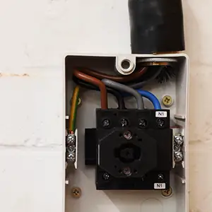 Internal wiring of a three‑phase isolator during installation.