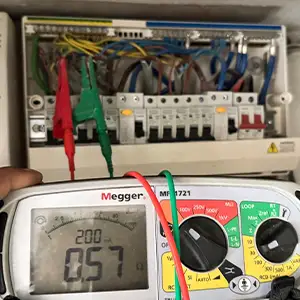 Electrician performing ring continuity testing inside a distribution board in SW9 using a Megger tester.